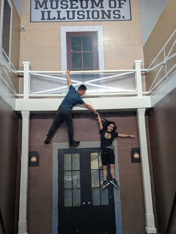 Illusion of two people dangling from a terrace