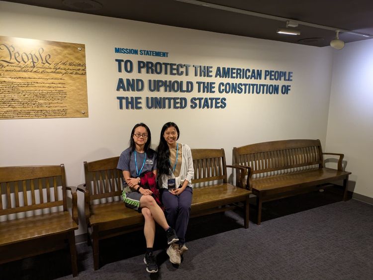 Women sitting in front of wall with FBI mission statement